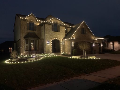 A well-decorated house with festive lights glowing at night.