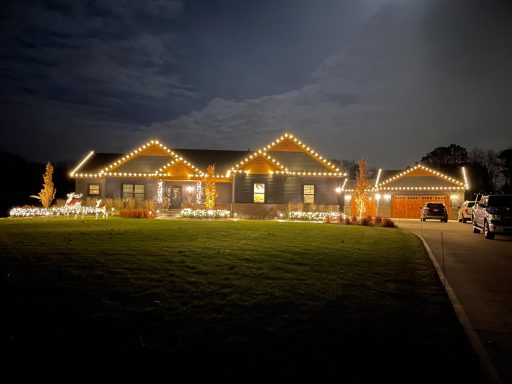 A modern house beautifully adorned with warm lights during the night.